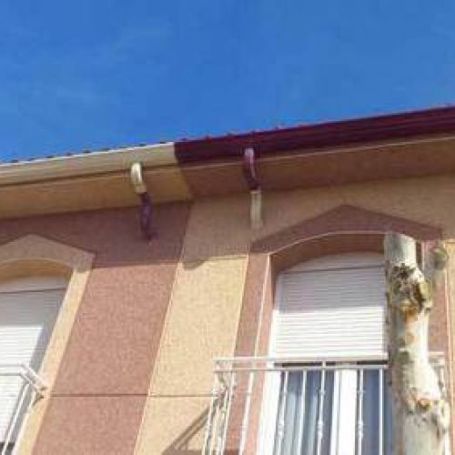 Detalle de canalón con bajante interior en dos colores