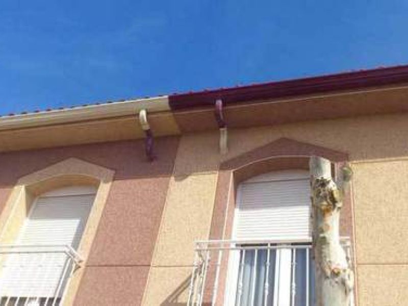 Detalle de canalón con bajante interior en dos colores