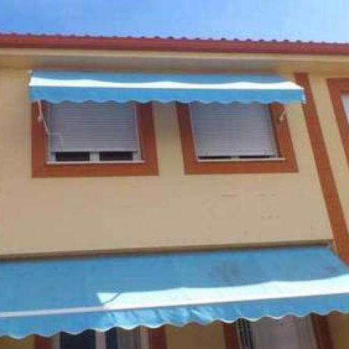 Fachada completa con canalón de chapa en tono rojo