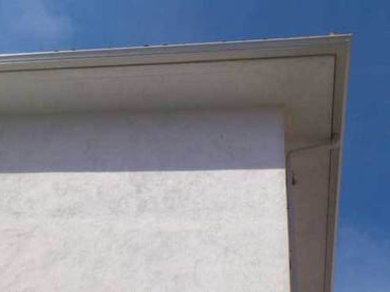 Canalón de chapa en tono gris sobre alero de tejado